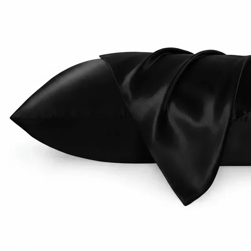 Fronha de seda preta brilhante para almofada, textura suave, fundo branco.