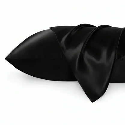 Fronha de seda preta brilhante para almofada, textura suave, fundo branco.